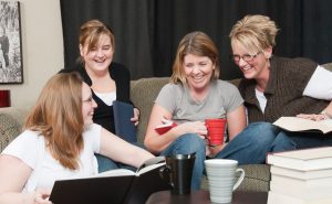 women sitting in group reading and smiling