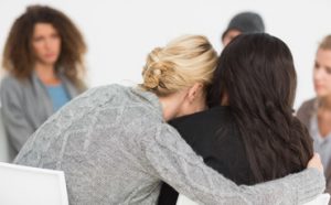 women in treatment hugging