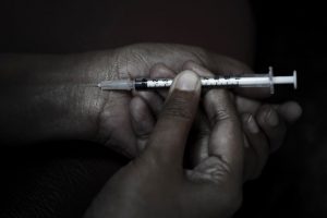 person shooting up heroin