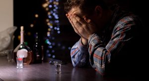 sad alcoholic man sitting at a bar